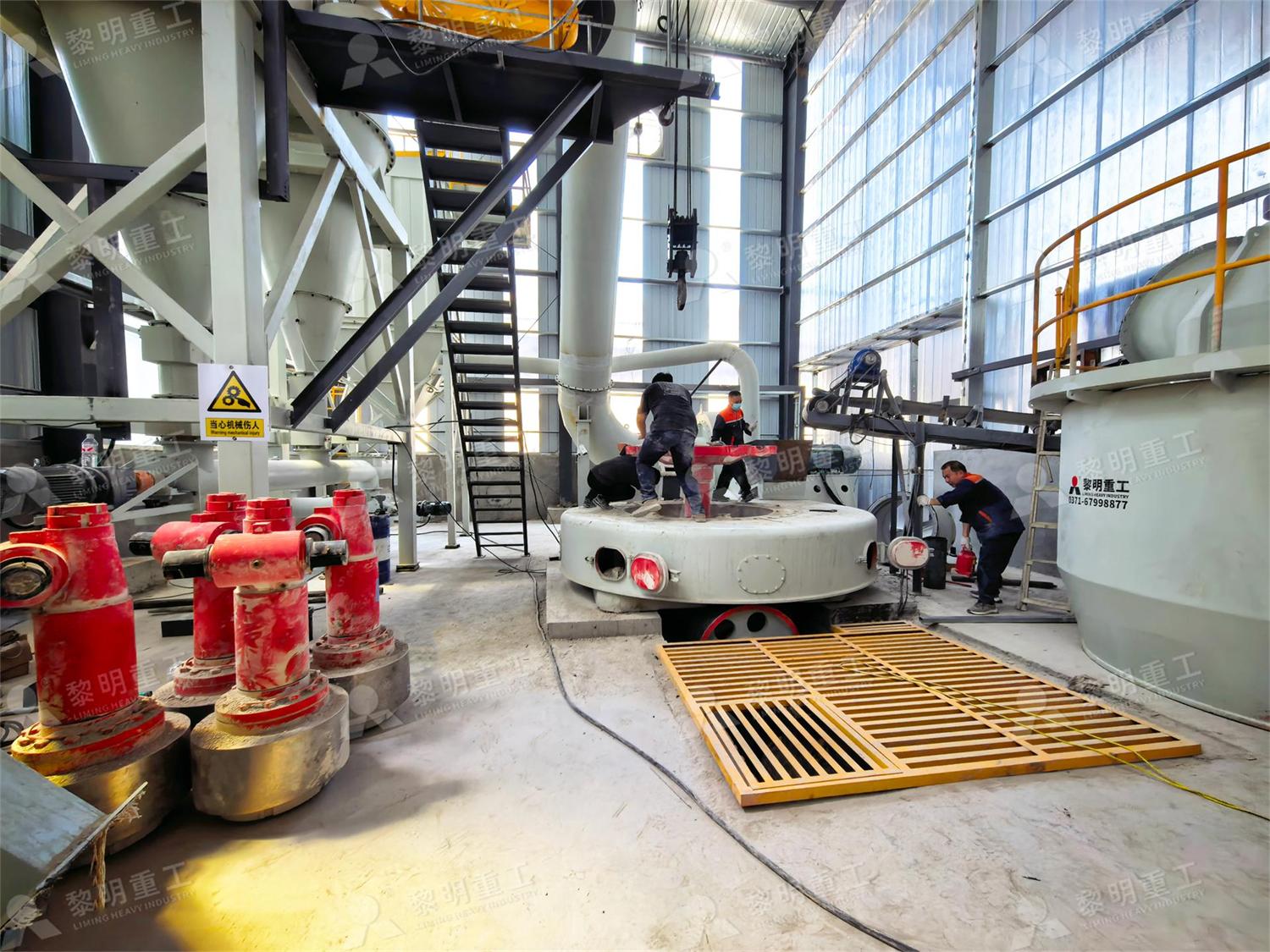 Workers install grinding roller of MTW6X mill for barite processing plant